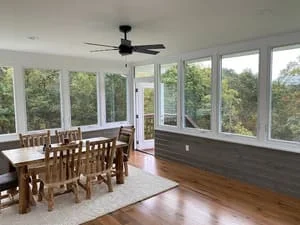 Sunroom with floor-to-ceiling windows, hardwood floors, and wainscoting