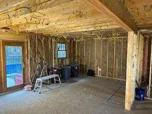 Interior framing with exposed beams, wall studs, and drywall installation in residential space