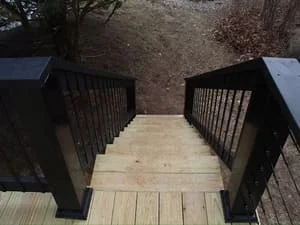 Composite deck with black metal railings and wooden support structure