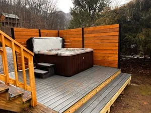 Composite deck with hot tub and horizontal cedar privacy fence panels