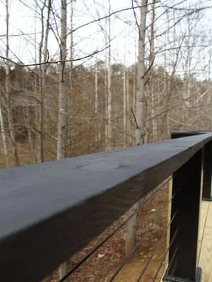Standing seam metal roof installation on residential home with wooded setting