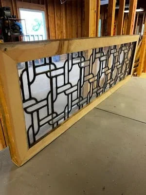 Wood-framed railing with geometric black metal lattice pattern and natural wood top rail