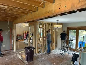 Interior renovation with exposed framing, new door openings, and structural modifications in progress